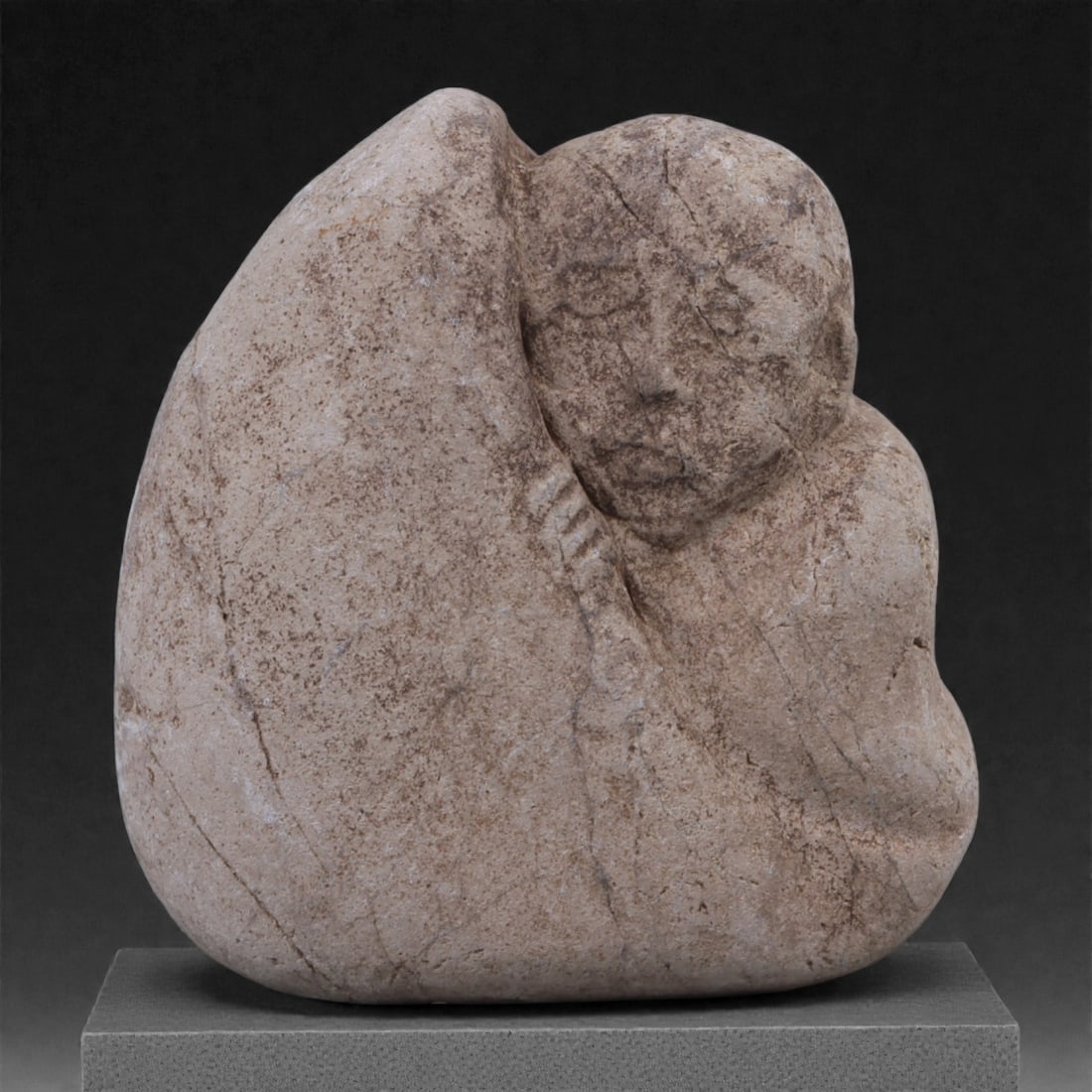 An Eastern Oriental Stone Figurine, 34P: Carved from a compact pale beige stone with fine granular texture and scattered darker mineral inclusions, the object is worked fully in the round as a small sculptural figure. The composition present
