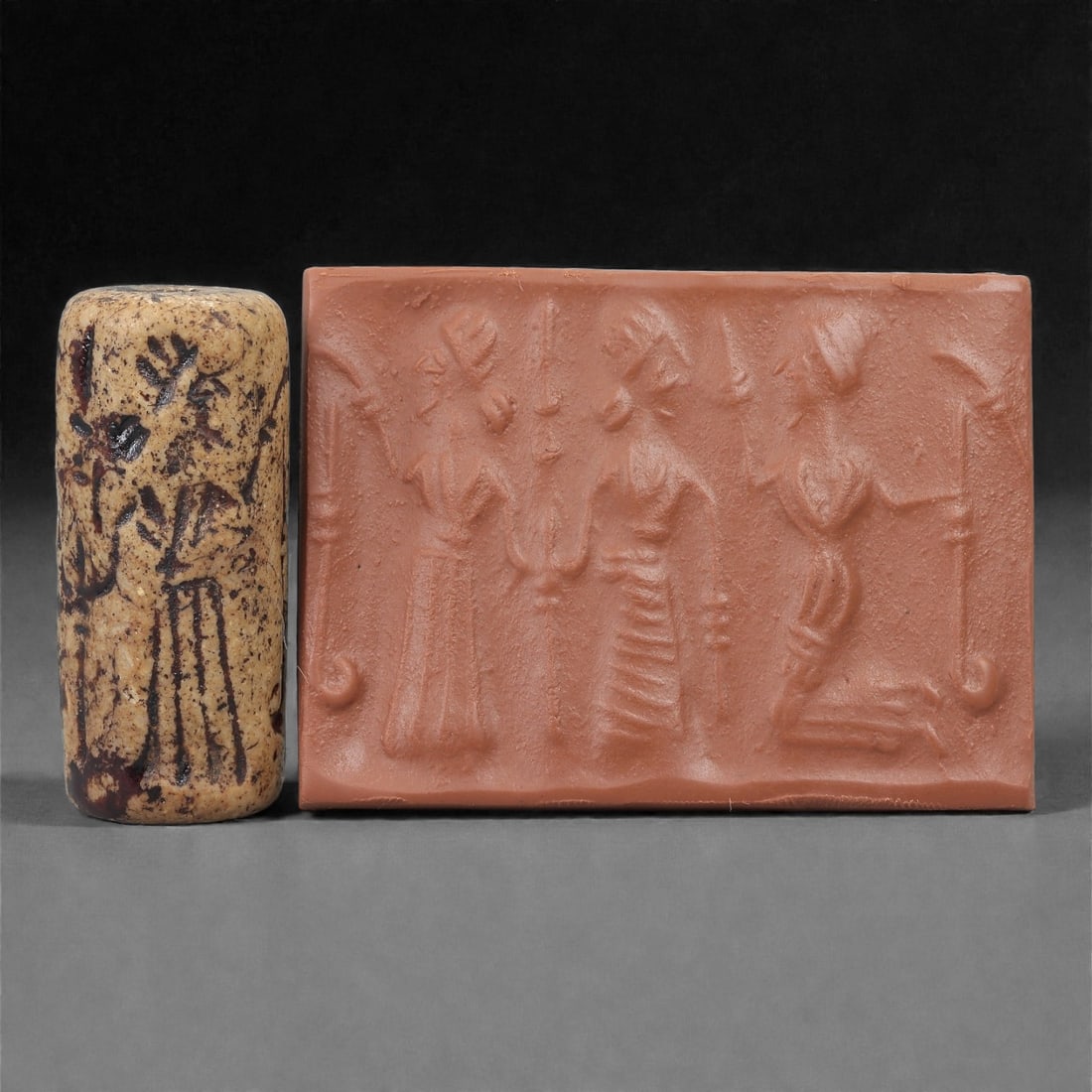 A Near Eastern Stone Cylinder Seal, 3rd Millennium BCE, 4cm, 24LH: Carved from stone with darker surface mottling, the cylindrical seal bears a continuous engraved scene. The carving is executed in shallow linear grooves typical of Early Bronze Age glyptic traditions