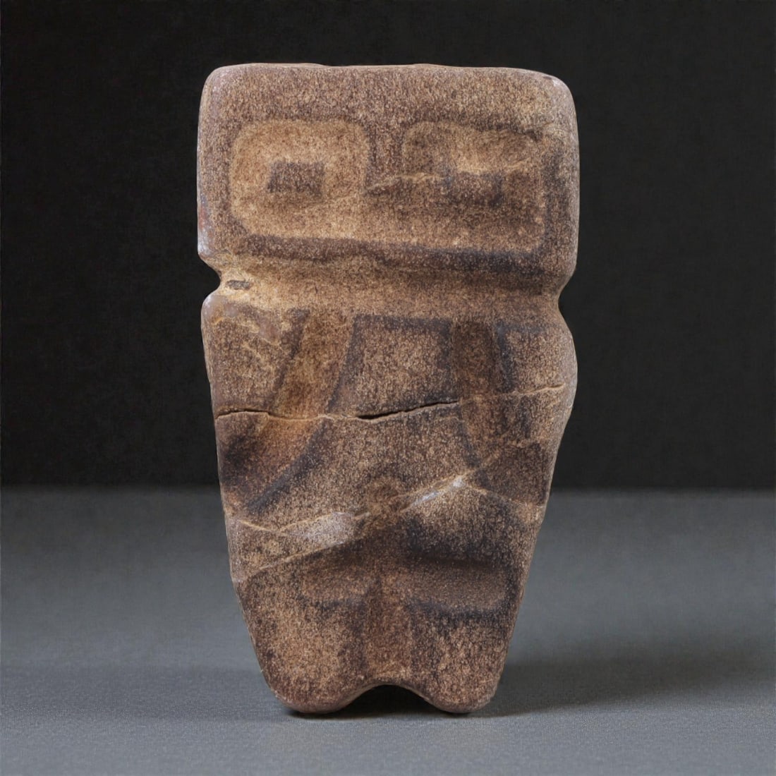 A Valdivian Stone Figure, Early Formative Period, Circa 3500-1500 BCE, 3.8cm, 94T: Carved from a fine-grained stone with a matte surface and minor natural inclusions, the figure is rendered in a compact, schematic manner characteristic of early Valdivian sculptural traditions. The f