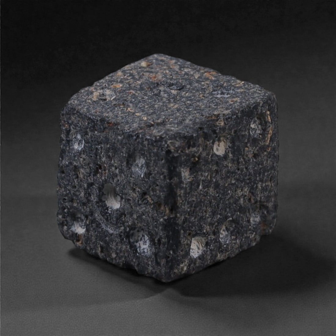 Ancient Roman Bone Gaming Die - Carved Dice, 0.9cm, 53E: Carved from dense animal bone, this miniature gaming die is carefully shaped into a cubic form with evenly proportioned faces and rounded edges softened through long use. The pips are drilled as shall