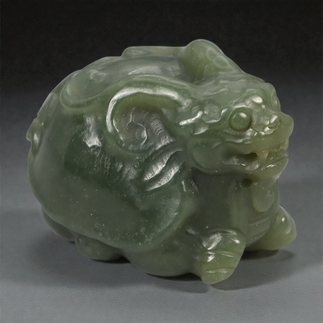 A Chinese Nephrite Jade Bixi Figure, 20th Century, 14YA: Carved from dark green nephrite jade with subtle tonal variation and areas of soft translucency, the figure represents bixi, the mythical creature traditionally depicted with the body of a tortoise an