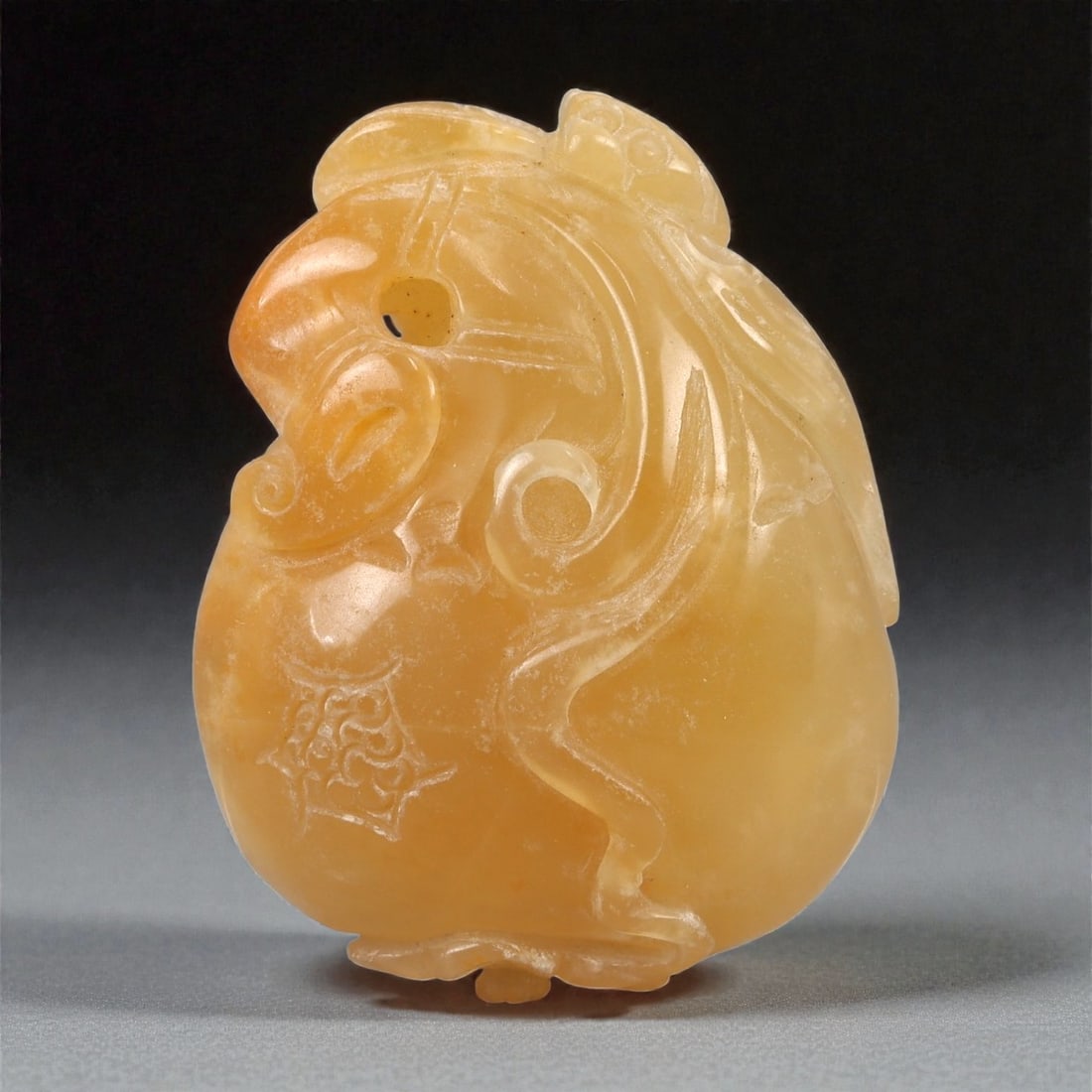 A Chinese Amber-Colored Hardstone Pendant with Zoomorphic Mask, 20th Century, 80FC (1 of 2)