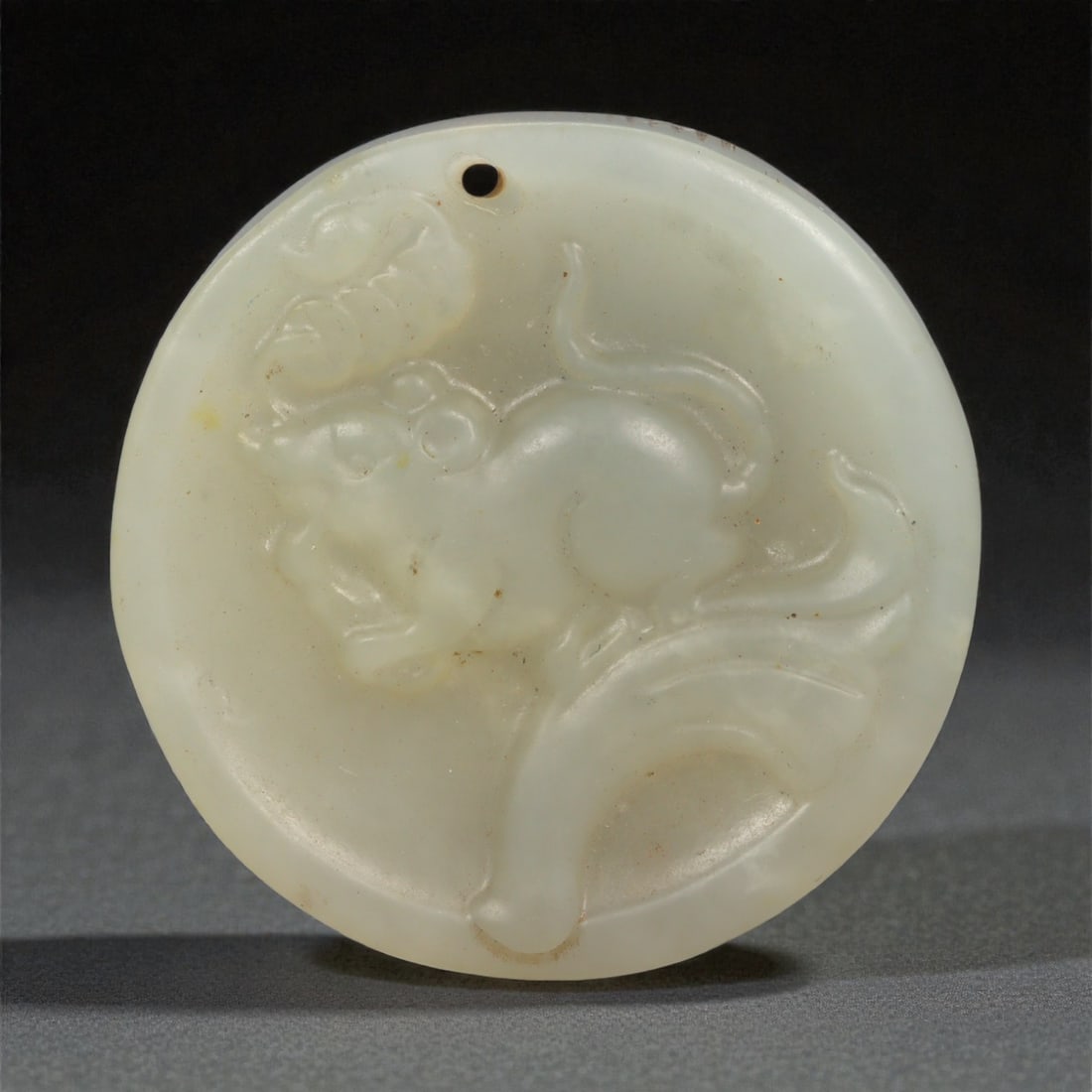 A Chinese Jade Dragon and Bagua Disc Pendant, 20th Century, 68YA: Carved from pale celadon jade with areas of russet and brown staining following the natural inclusions of the stone, the pendant is circular in form and worked in low relief on both faces. One side de