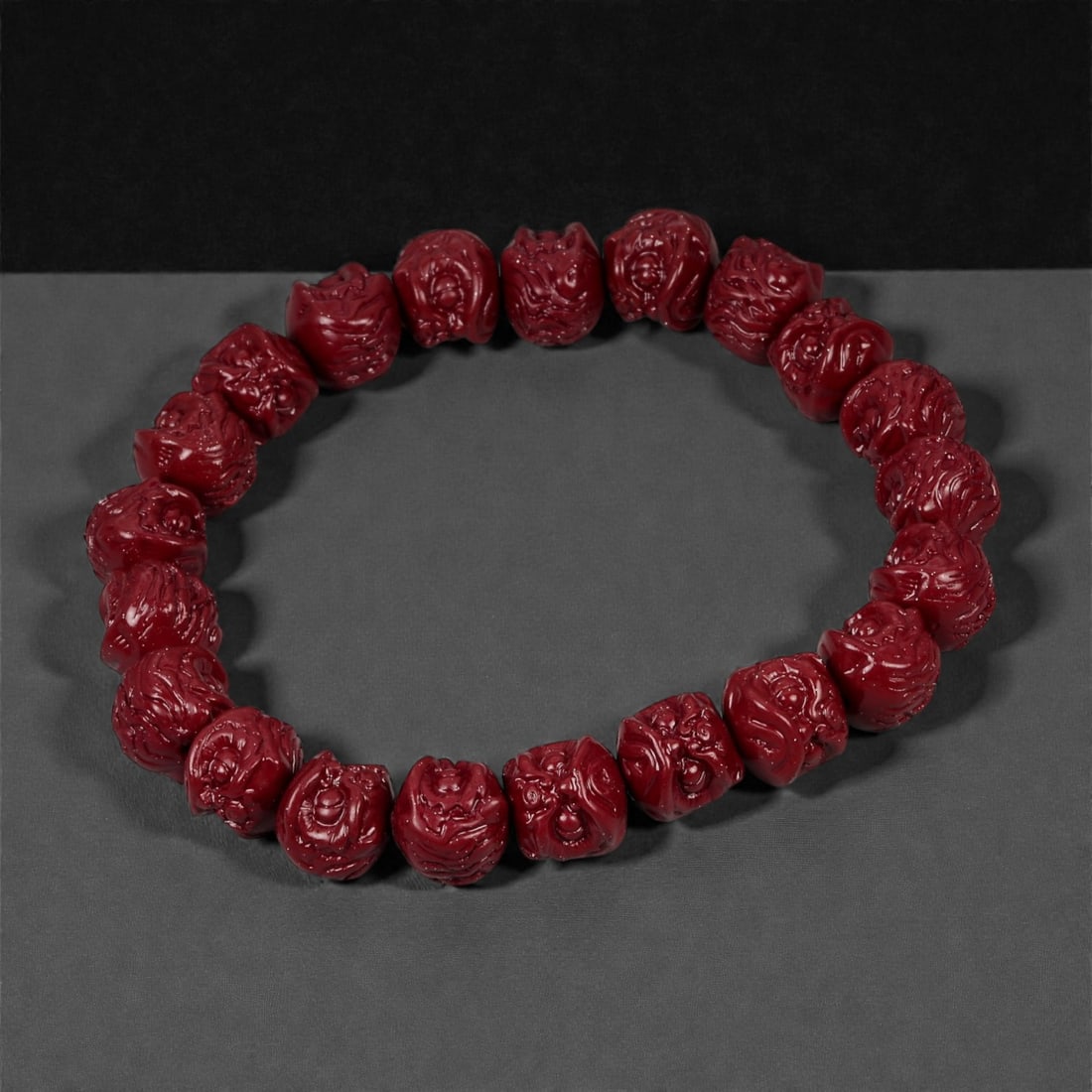 A Chinese Cinnabar Carved Bead Bracelet, 20th Century, 52FD: Composed of small spherical beads carved from cinnabar, a mercury sulfide material traditionally employed in Chinese ornamental production. Each bead is centrally pierced and carved in low to moderate