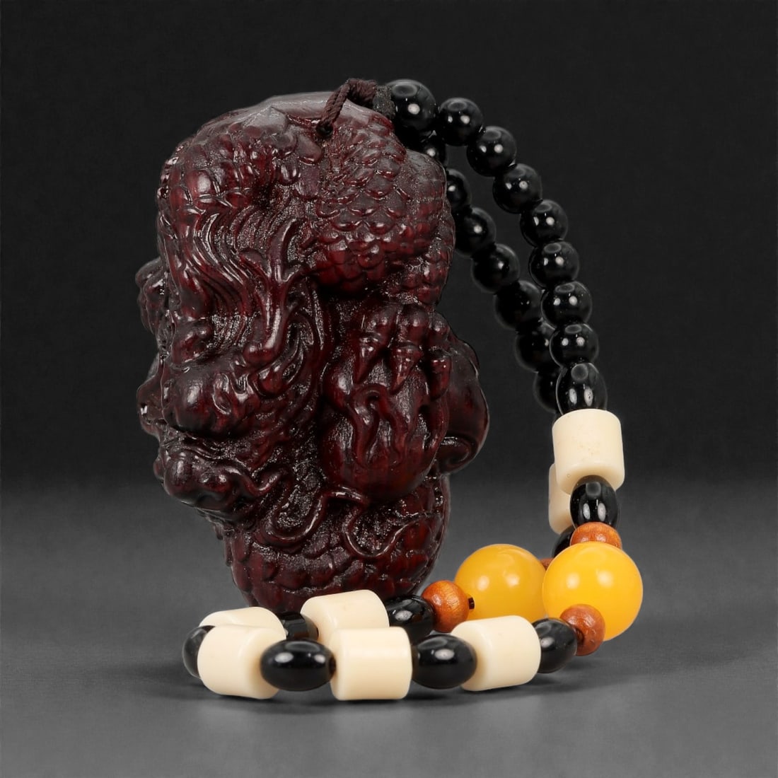 A Chinese Wood Dragon Figure, 20th Century, 60FD: Carved from dark reddish-brown wood with a polished surface, the figure represents a dragon rendered in a compact, vertically oriented form. The body is densely modeled with curling limbs, flowing man