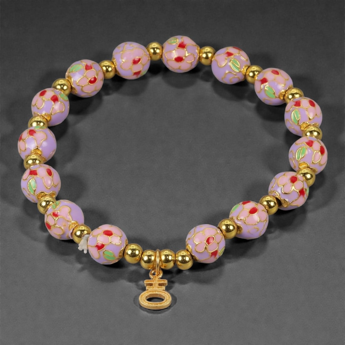 A Chinese Cloisonne Enamel Bracelet, 20th-21st Century, 80YB: Formed as a circular bracelet composed of spherical cloisonne enamel beads alternating with small gilt metal spacers. The beads are decorated with opaque lavender enamel grounds, articulated with fine