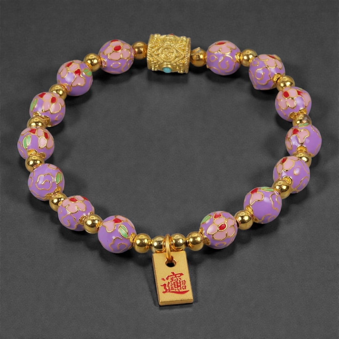 A Chinese Cloisonne Enamel Bracelet, 20th-21st Century, 84YB: Constructed as a circular bracelet composed of spherical cloisonne enamel beads interspersed with small gilt metal spacers. The beads are decorated with opaque lavender-purple enamel grounds, articula