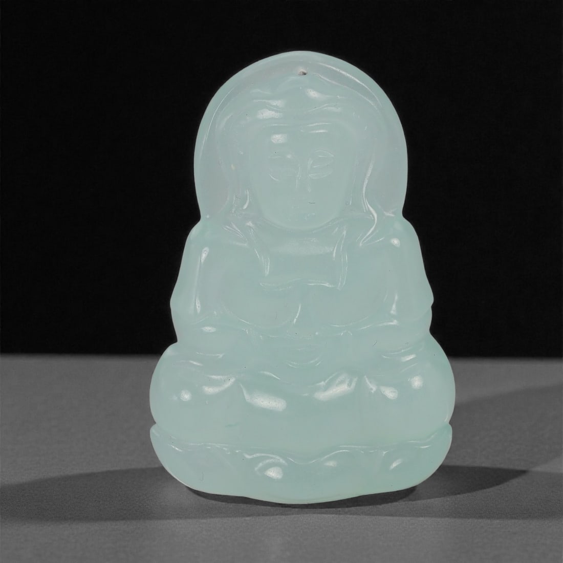 A Chinese Aquamarine Buddha Amulet Pendant, 20th Century, 53YB: Carved from pale aquamarine with a translucent blue-green tone and subtle internal clouding, the pendant depicts a seated Buddha shown frontally in a meditative posture, with hands resting in the lap