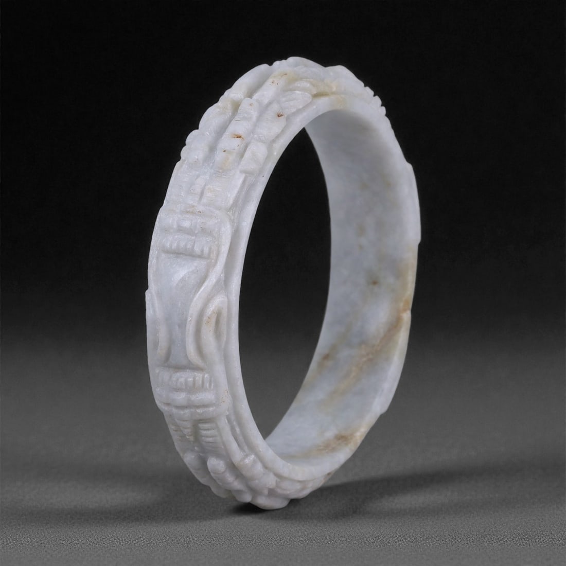 Carved Jade Bracelet - Asian Dragon Motif Bangle, 38WE: Carved from pale grey-white jade with subtle natural inclusions, this bracelet is formed as a continuous circular bangle, hollowed and shaped through abrasion and hand carving. The stone displays a de