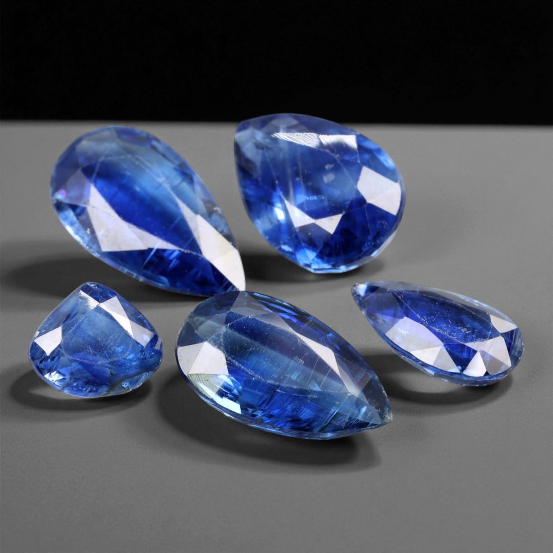 17.43 Carats Deep Blue Kyanite Pear Cut Selection - Natural Nepalese Stones - 7 to 15 mm, 9XE: This luminous selection of five kyanite gems showcases vibrant shades of royal to midnight blue, with subtle silken textures that are signature to the species. Each stone is fashioned in a pear or dro