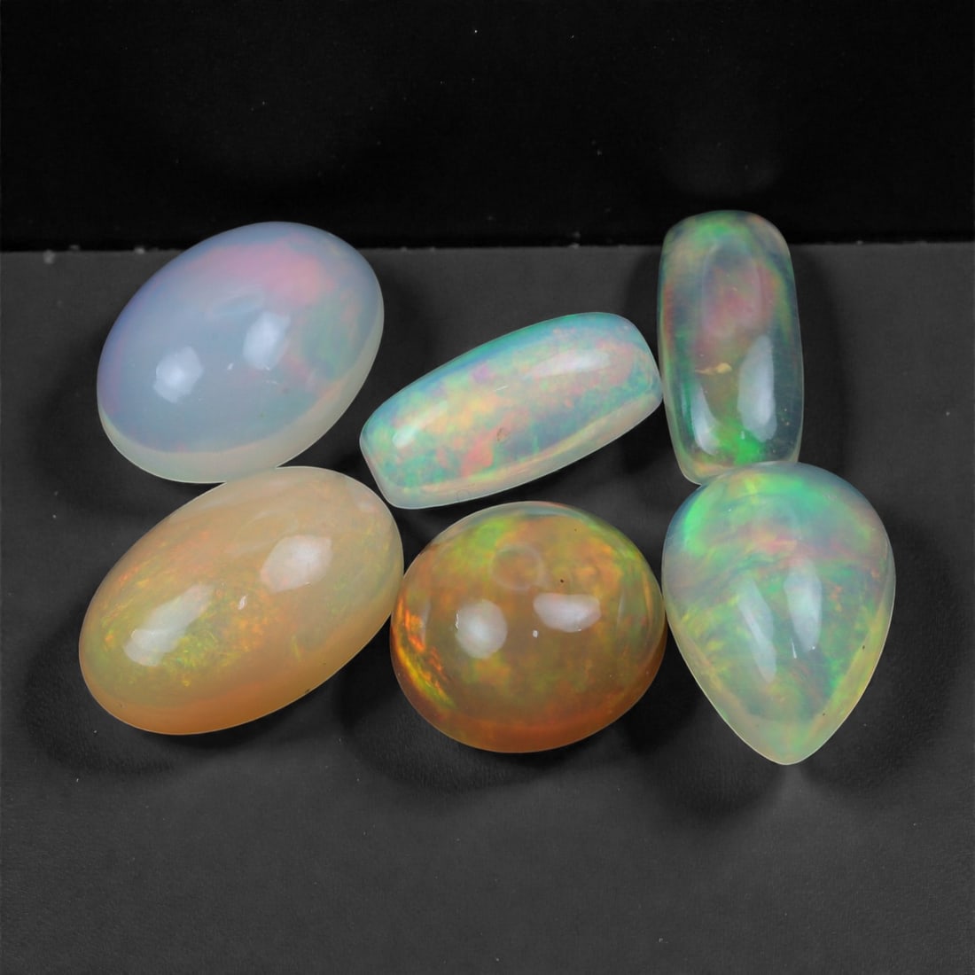 8.61 Carats Ethiopian Opal Cabochon Lot - Natural Welo Stones - 9 to 11mm, 8XA: This vibrant lot of six Ethiopian opal cabochons features a luminous display of color play, with swirling flashes of neon green, sunset orange, violet, and aqua blue glowing beneath soft translucent t
