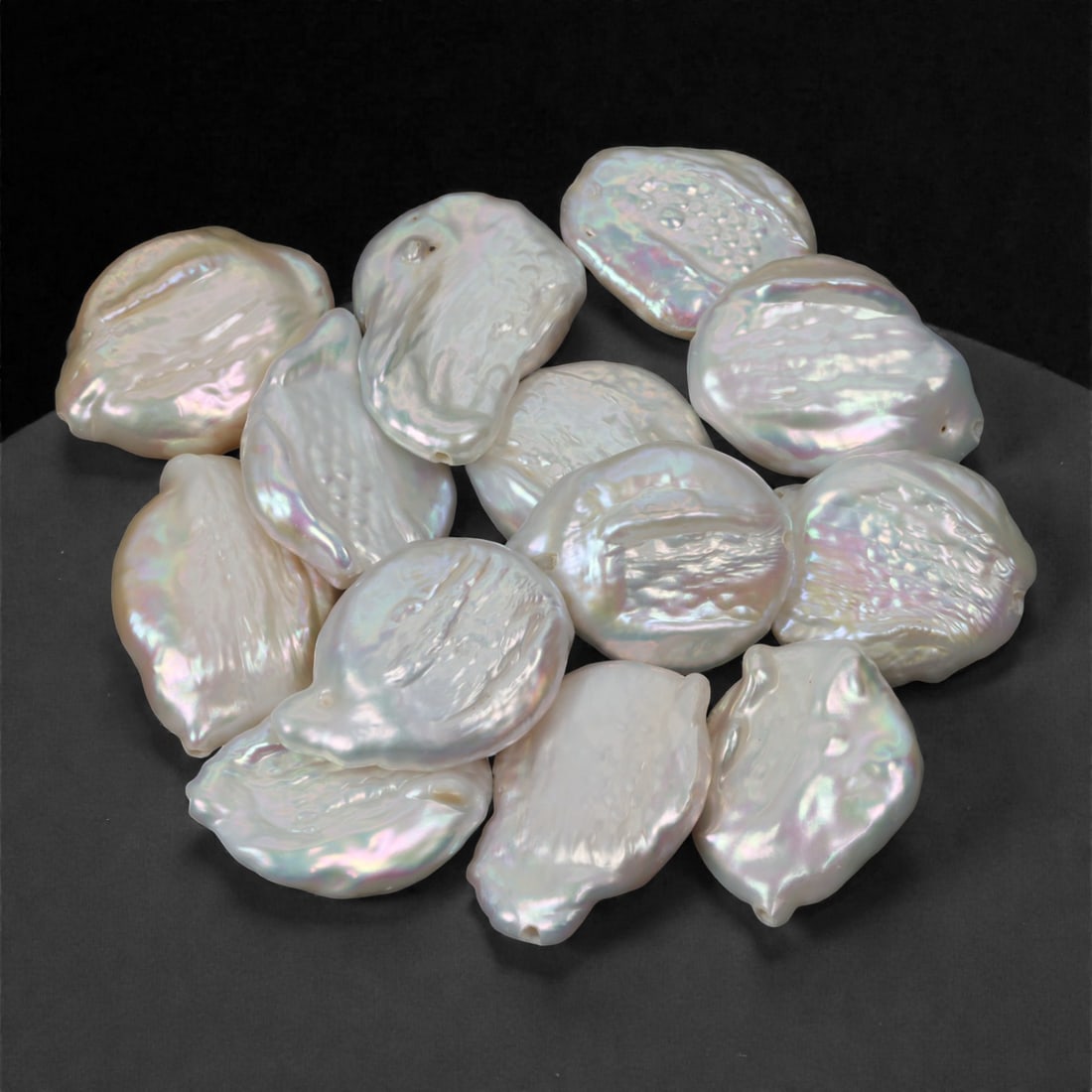 145.21 Carats Iridescent White Baroque Pearl Lot - Natural Freshwater Origin, 33XJ: This graceful lot of baroque pearls glows with soft white body tones illuminated by subtle pink, lavender, and aqua overtones. Their organic forms and high luster create a sense of refined asymmetry, 