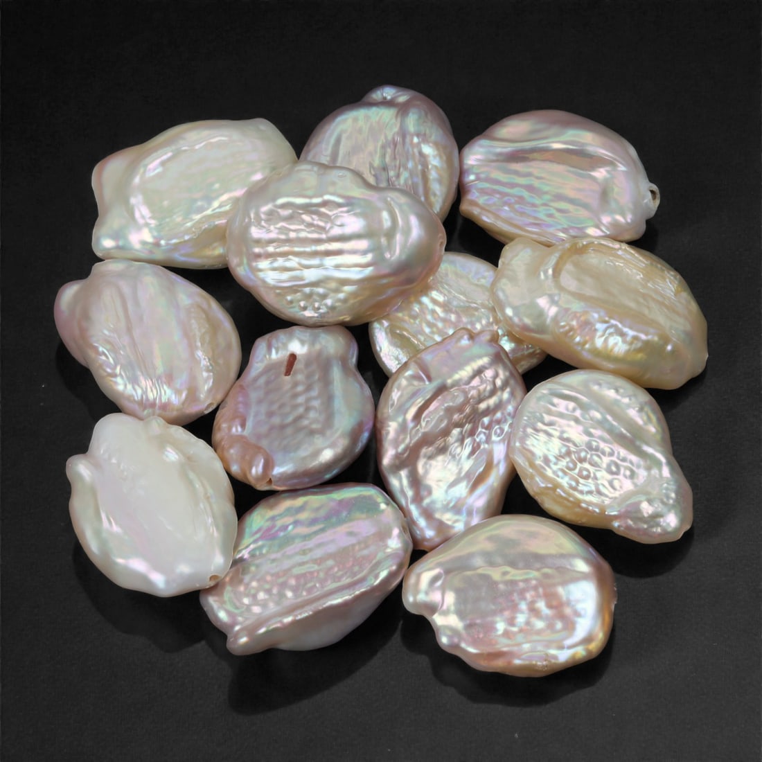 171.50 Carats Iridescent White Baroque Pearl Selection - Natural Freshwater Origin, 30XJ: This striking selection of baroque pearls radiates with shimmering iridescence and rich nacre luster, showcasing soft pinks, silvery lavenders, and subtle green overtones. Each pearl is uniquely sculp