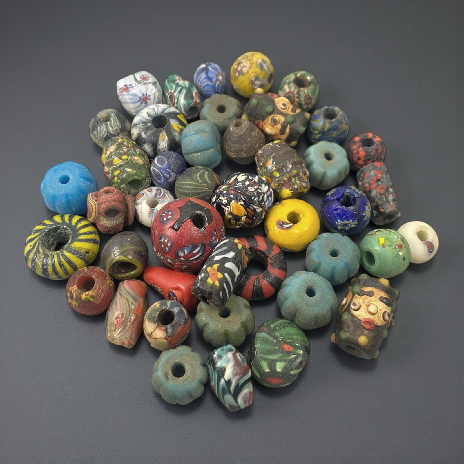 A Group of European and African Glass Trade Beads, 18th-20th Century, 27W: Comprising a mixed group of glass beads of varied manufacture, the assemblage includes spherical, ring-shaped, cylindrical, and melon-form examples, each perforated for stringing. The beads are produc