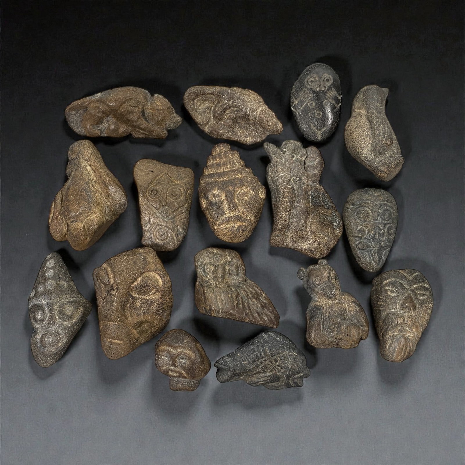 A Near Eastern Bone Amulet Group, 3rd-1st Millennium BCE, 74W: The group comprises sixteen small amulets carved from bone, worked in low relief and exhibiting a diverse range of schematic zoomorphic and anthropomorphic forms; the material shows natural tonal vari