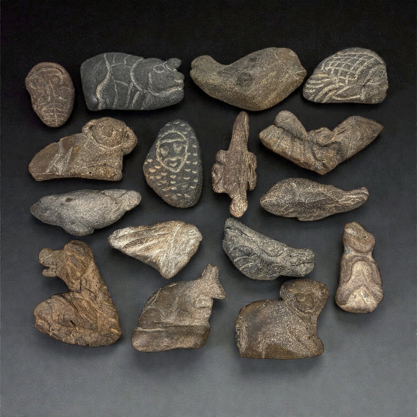 A Near Eastern Bone Amulet Group, 3rd-1st Millennium BCE, 71W: The group comprises sixteen small amulets carved from bone, worked in low relief and presenting a range of schematic zoomorphic and anthropomorphic forms; the material exhibits natural tonal variation