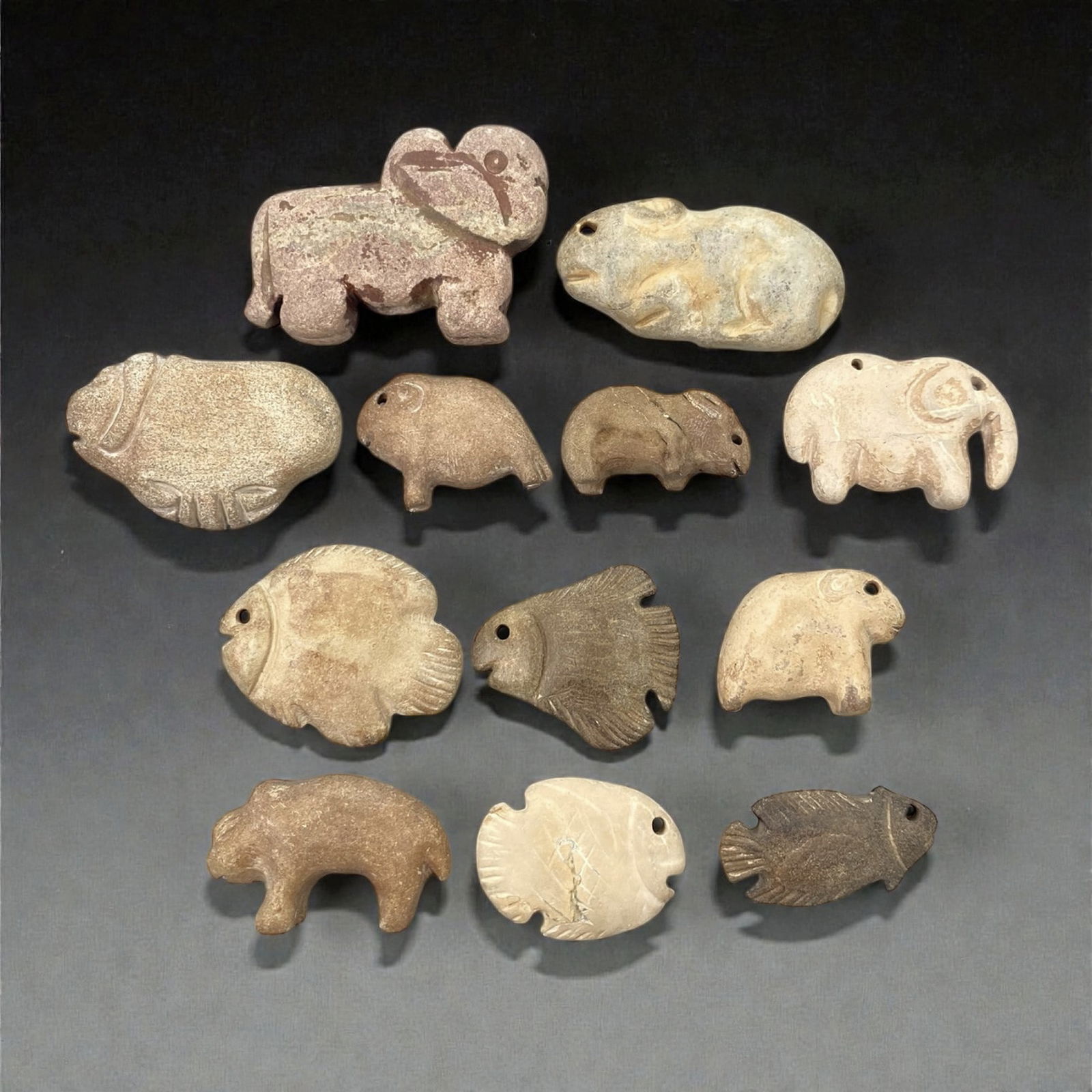 A Group of Near Eastern Stone Zoomorphic Figurines, 3rd-2nd Millennium BCE, 44XJ: Carved from various types of light to medium-toned stone, including examples with visible natural inclusions and surface patination, the group comprises twelve small zoomorphic figurines. Each is work