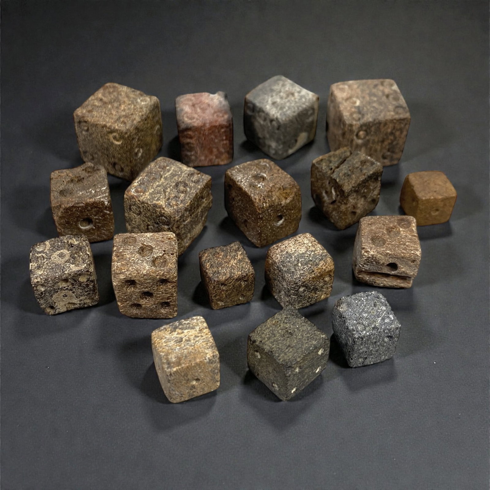 A Group of Roman Bone Dice, 1st-3rd Century CE, 48XJ: Comprising twelve small cubic dice carved from bone, each example is formed with drilled circular pips arranged on opposing faces according to Roman numerical conventions, with slight irregularities i