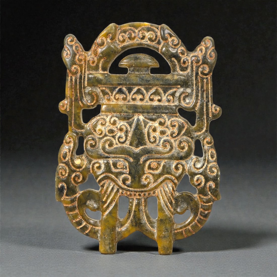 A Chinese Jade Openwork Plaque, 20th Century, 51FC: Carved from mottled jade with olive-green, dark green, and warm russet inclusions, the plaque is worked in openwork and low relief to form a vertically oriented, symmetrical composition. The central m