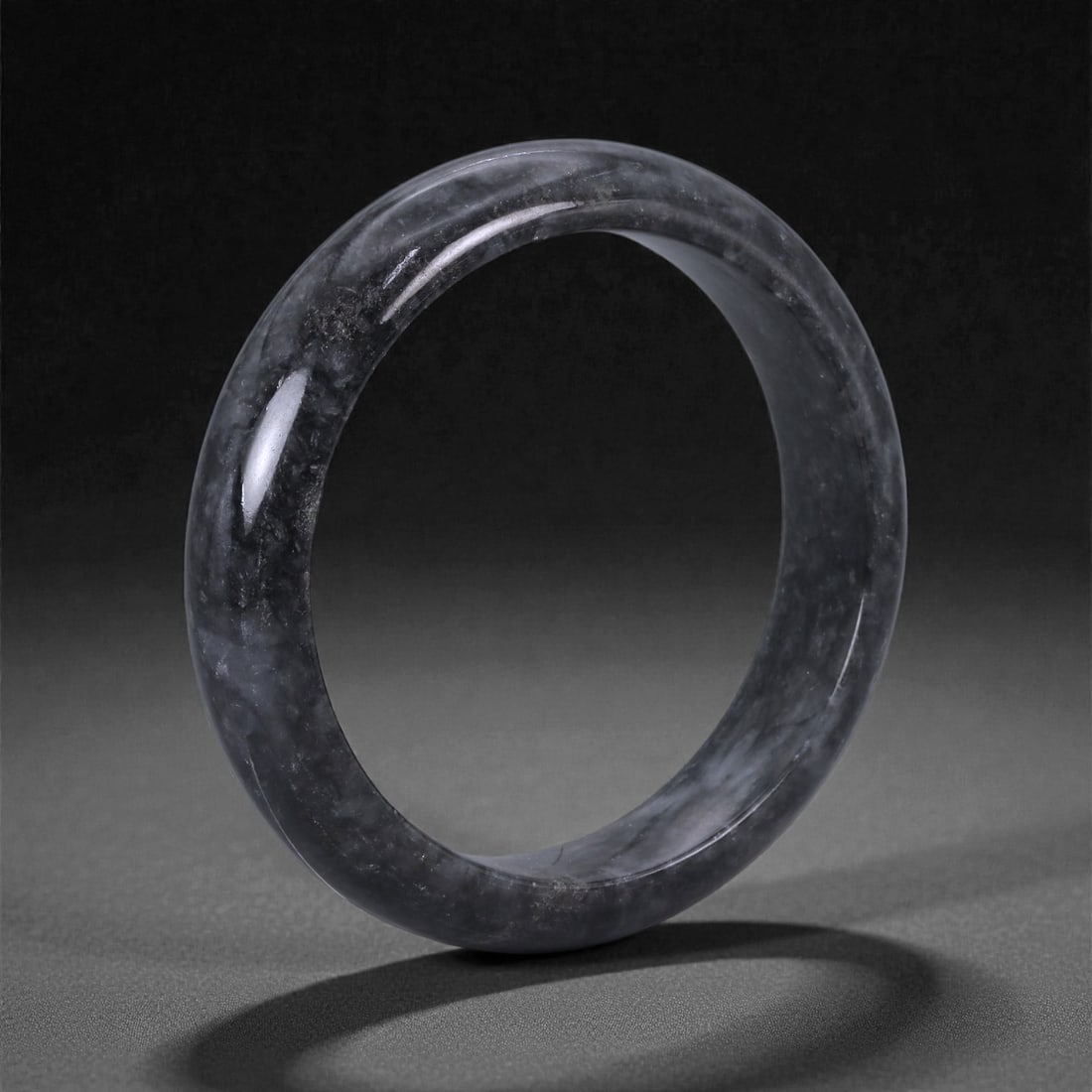 A Chinese Jadeite Bracelet Bangle, 5.9cm Inner Diameter, 18WE, 18WE: Carved from jadeite, the bracelet is formed as a continuous circular bangle with a rounded cross-section and a uniformly polished surface. The interior and exterior edges are smoothly finished, indica