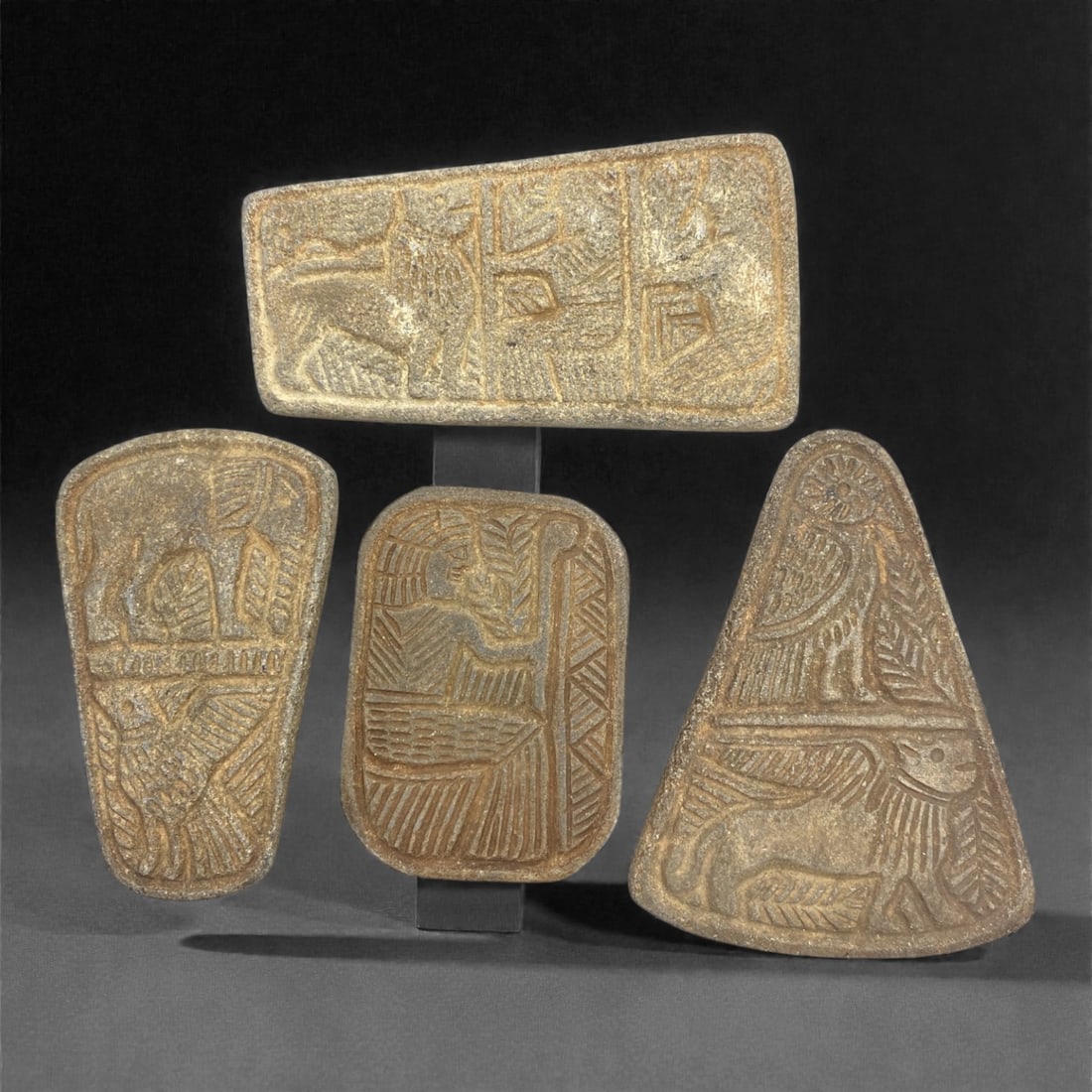 A Sasanian Lapis Lazuli Relief Plaque Group, 3rd-7th Century CE, 70W: Comprising four relief plaques carved from lapis lazuli, each example is worked in low relief with figural and decorative motifs associated with Sasanian visual traditions. The group includes plaques