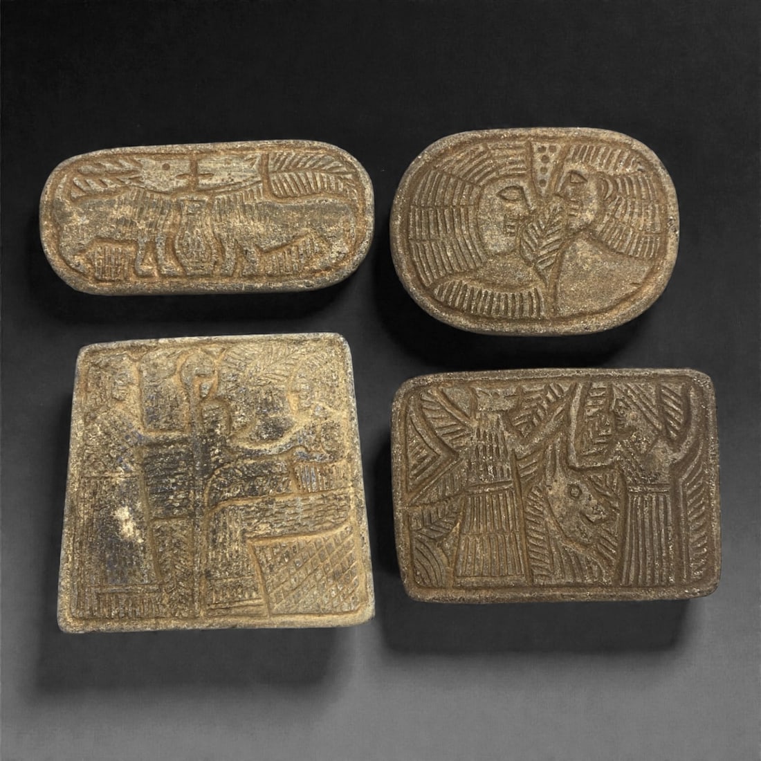 A Sasanian Lapis Lazuli Relief Plaque Group, 3rd-7th Century CE, 61V: Comprising four carved relief plaques of rectangular and oval formats, worked in lapis lazuli or lapis-rich stone with muted blue inclusions and surface abrasion consistent with age, each plaque is ex