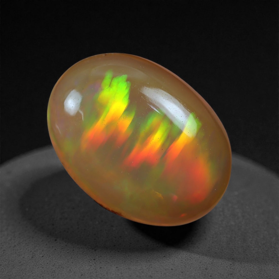 2.14 Carats Play-of-Color Welo Opal - Natural Ethiopian Gem 12x8mm, 22XC: This captivating Welo opal gleams with a luminous cascade of multi neon color that ripple across the stone's surface with every movement. The play-of-color is vivid and well-distributed, presenting a