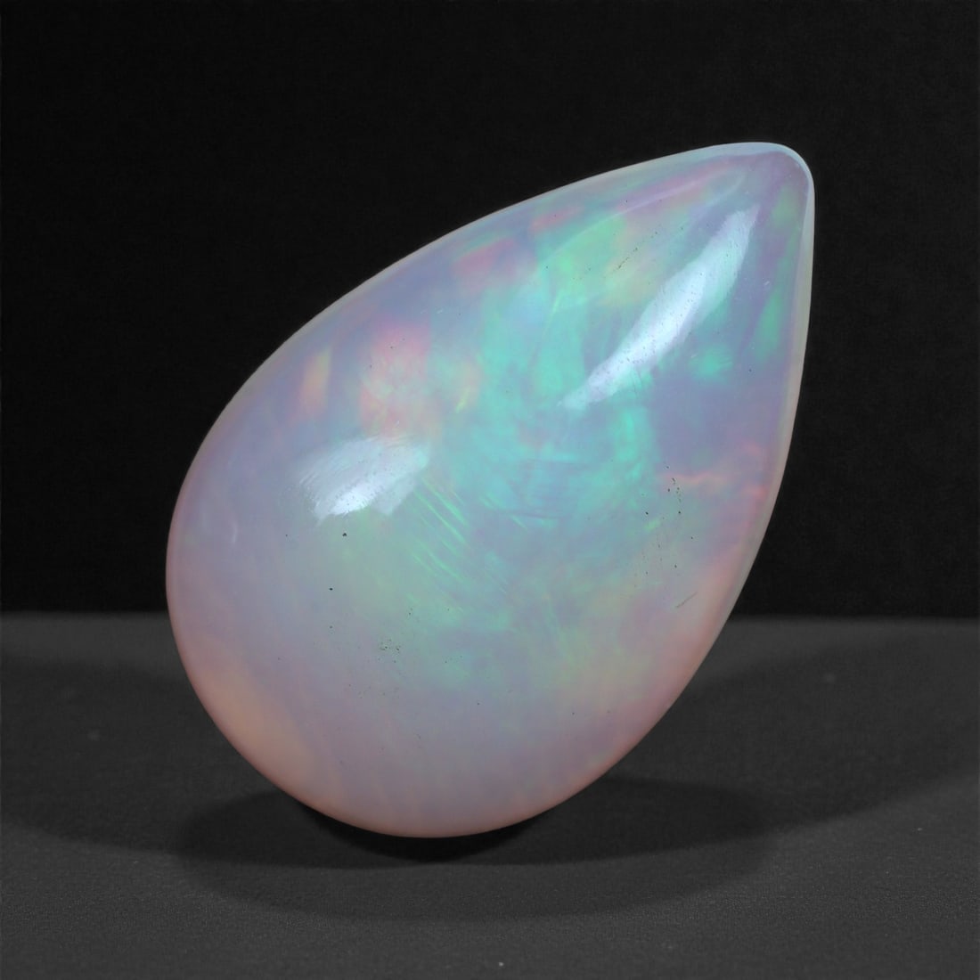 4.69 Carats Play-of-Color Welo Opal - Natural Ethiopian Gem 17x11mm, 45XA: This captivating Welo opal gleams with a luminous cascade of multi neon color that ripple across the stone's surface with every movement. The play-of-color is vivid and well-distributed, presenting a