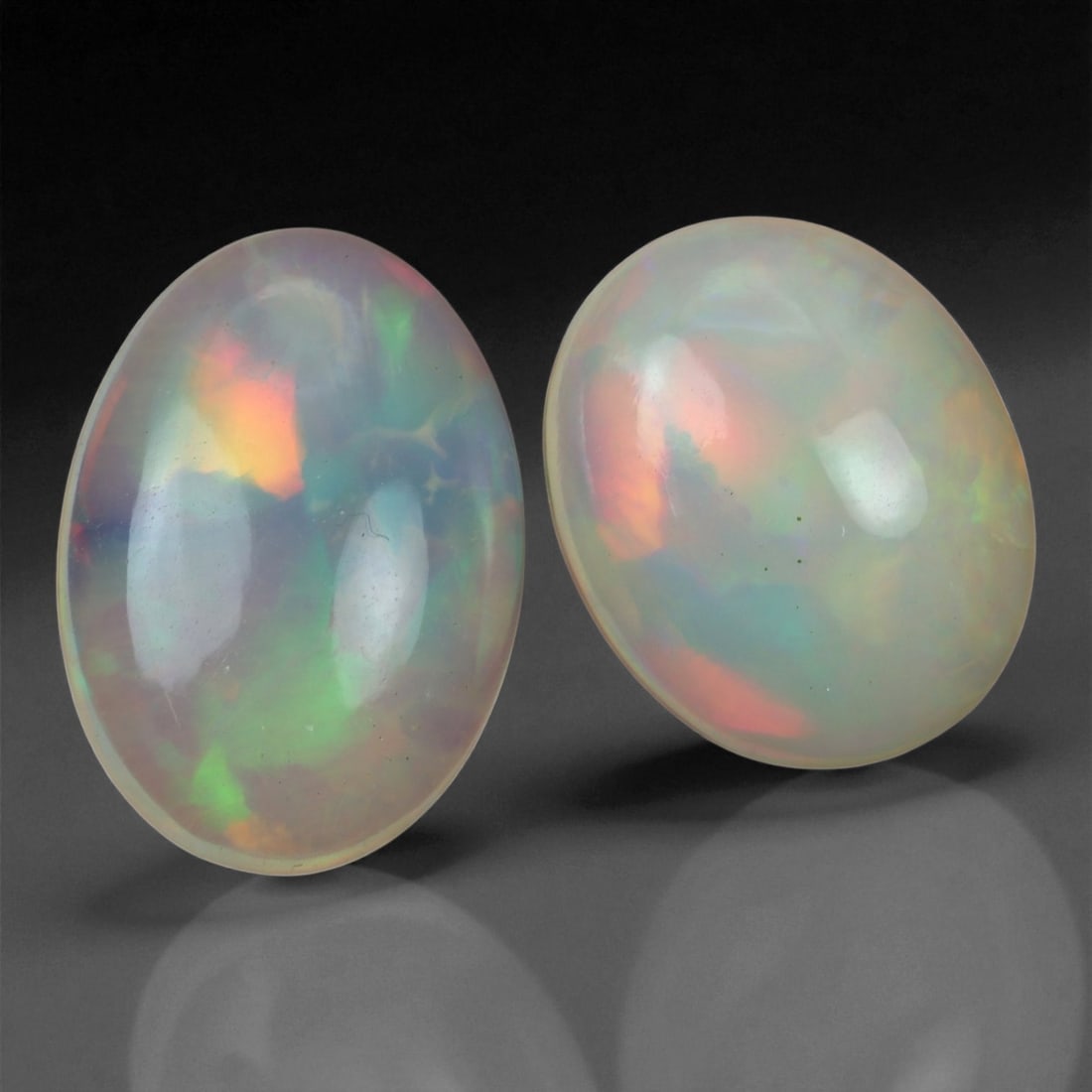6.48 Carats Pastel Fire Opal Pair - Natural Ethiopian Welo Stones, 90XC: This graceful duo of Ethiopian opals glows with soft pastel brilliance, showcasing flashes of peach, mint green, lilac, and gentle gold beneath their milky translucent bodies. Cut in well-balanced ova