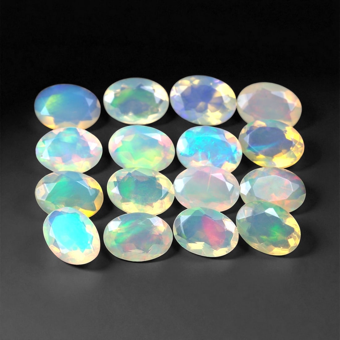 7.84 Carats Oval Cabochon Opal Parcel - Natural Welo Ethiopian Stones, 94XC: This mesmerizing parcel features 7x5 mm oval-cut opals, each glowing with exceptional play-of-color across a luminous, translucent body. Flashes of electric green, oceanic blue, and golden orange shif