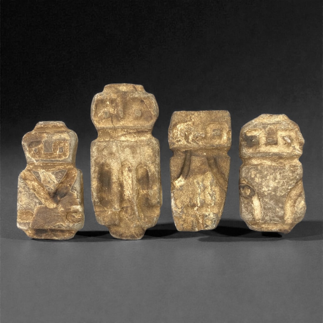 A Group of Valdivian Stone Anthropomorphic Figures, Ecuador, Circa 3500-1500 BCE, 16W: Comprising four small anthropomorphic figures carved from light brown stone, each example is rendered in a compact standing form with block-like bodies, abbreviated limbs, and simplified facial featur