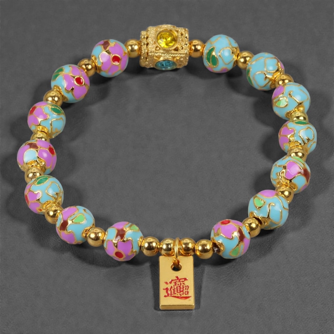 A Chinese Cloisonne Enamel Bracelet, 20th-21st Century, 88YB: Composed of a sequence of spherical cloisonne enamel beads alternating with small gilt metal spacers, strung to form a circular bracelet. The beads are decorated with polychrome enamel fields in turqu