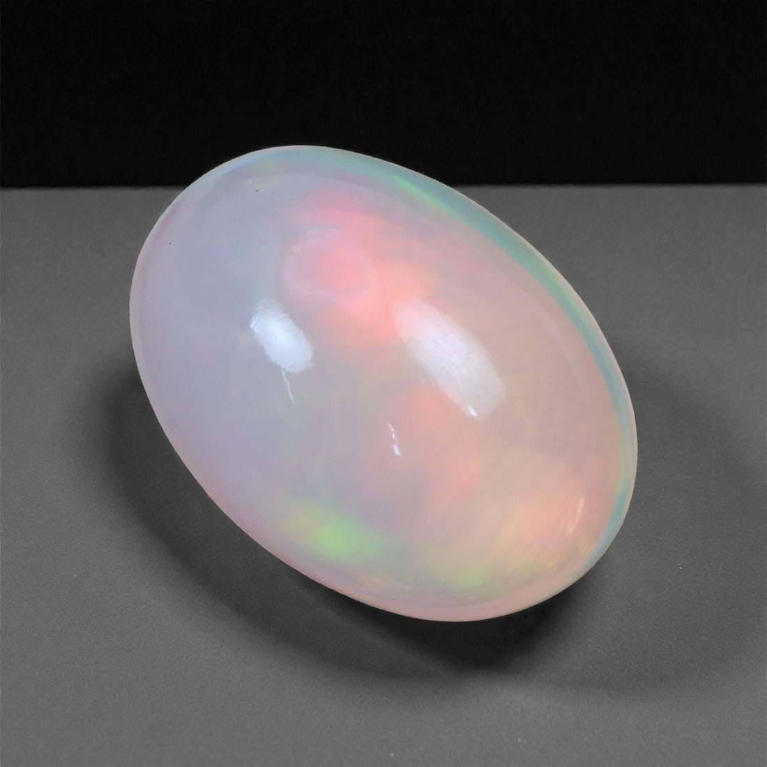 3.83 Carats Blush Flame Welo Opal - Natural Ethiopian Gemstone 13x9.3x6.7mm, 37XH: Glowing with soft pink, coral, and lime flashes, this Welo opal captures a dreamy interplay of light and warmth beneath a smooth, milky surface. Its pastel fire radiates gently throughout the stone, c