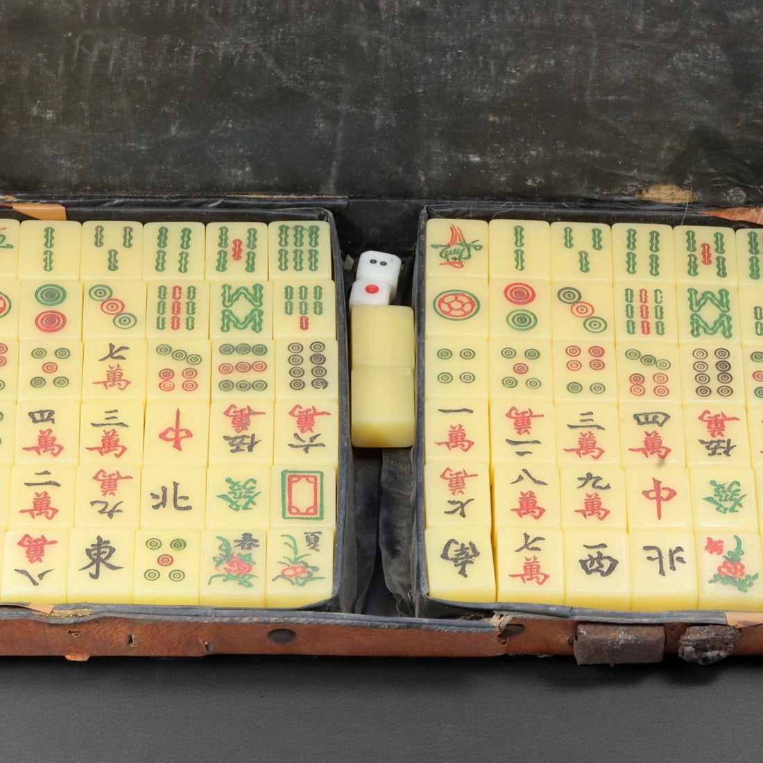 A Chinese Composite Mahjong Set, Mid-20th Century, 51YC: The set comprises a complete group of mahjong tiles housed in a fitted rectangular case, the tiles manufactured from a composite material with incised and polychrome-decorated faces displaying standar