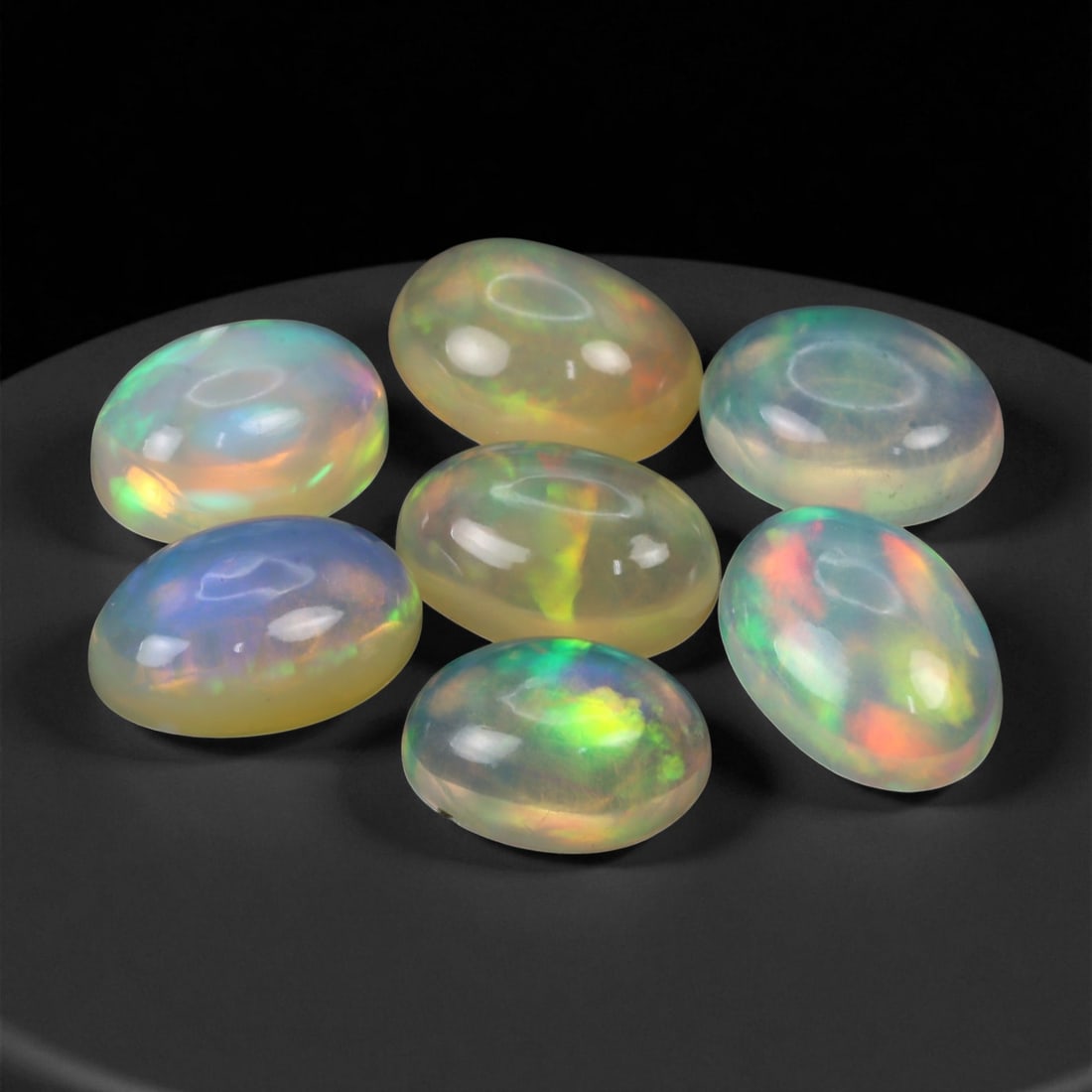 9.09 Carats Neon Play-of-Color Opal Selection - Natural Ethiopian Cabochons - 8 to 10 mm, 88XE: This luminous selection of opals radiates a dynamic spectrum of neon hues, with flashes of electric green, vivid orange, and spectral blue dancing across each dome. Their translucent base allows the i