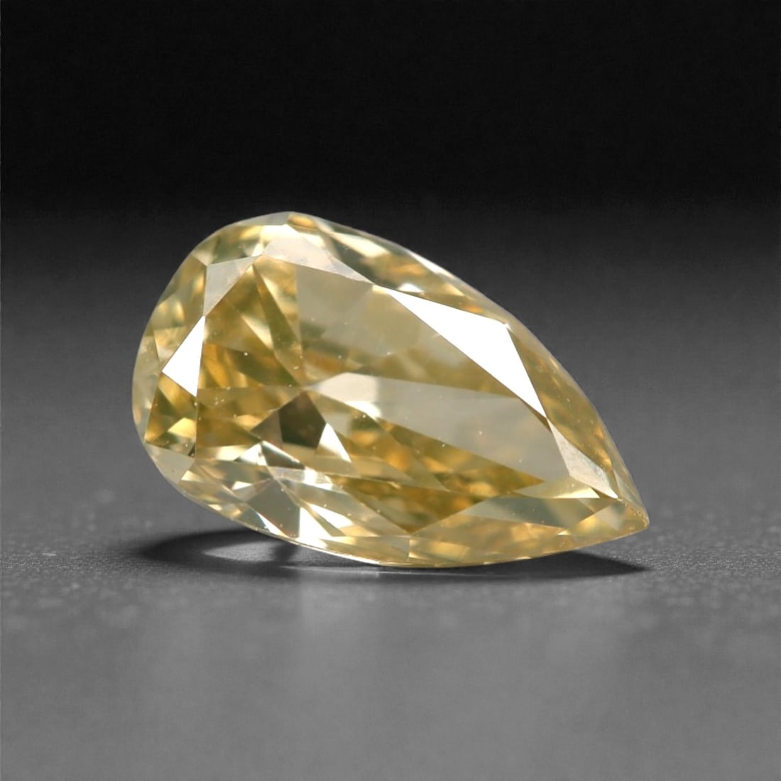 0.43 Carats Fancy Light Yellow Diamond - Natural South African Origin, 18DA: This 0.43 carat fancy light yellow diamond glows with a soft, buttery hue reminiscent of sun-warmed honey, its pear brilliant cut amplifying a luminous, lively sparkle across every precisely polished