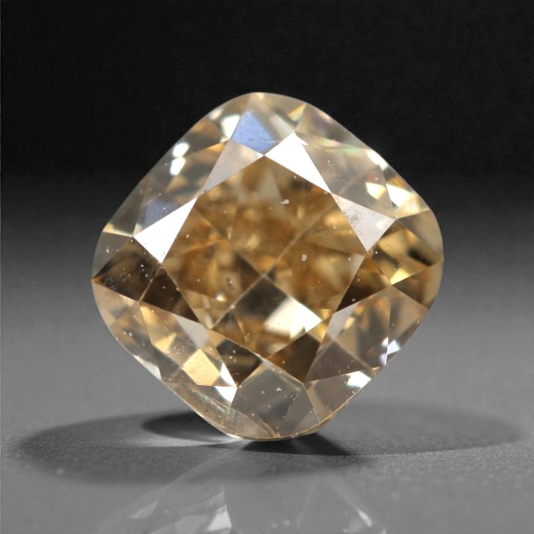 0.49 Carats Fancy Light Brownish Yellow Diamond - Natural South African Origin, 20DA: This 0.49 carat fancy light brownish yellow diamond exudes a warm, champagne hue with subtle golden undertones, its cushion modified brilliant cut amplifying a luminous, lively sparkle across every pr