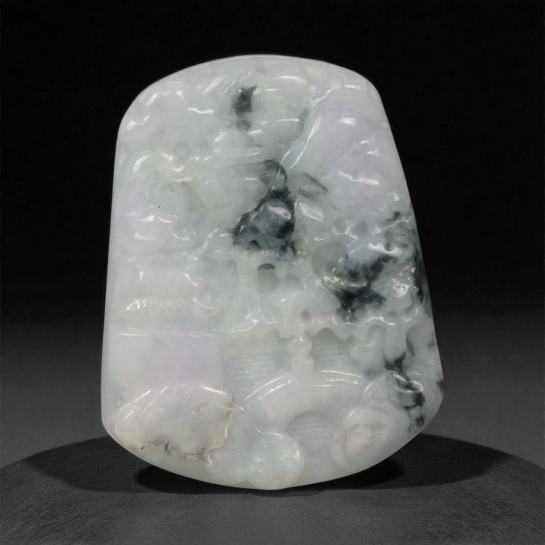 Chinese Jade Plaque - Carved Stone Relief, 66ZD: Carved from pale celadon jade with dark mineral inclusions, this small plaque is worked in low relief with stylized motifs and softly modeled contours, the composition emerging subtly from the stone r