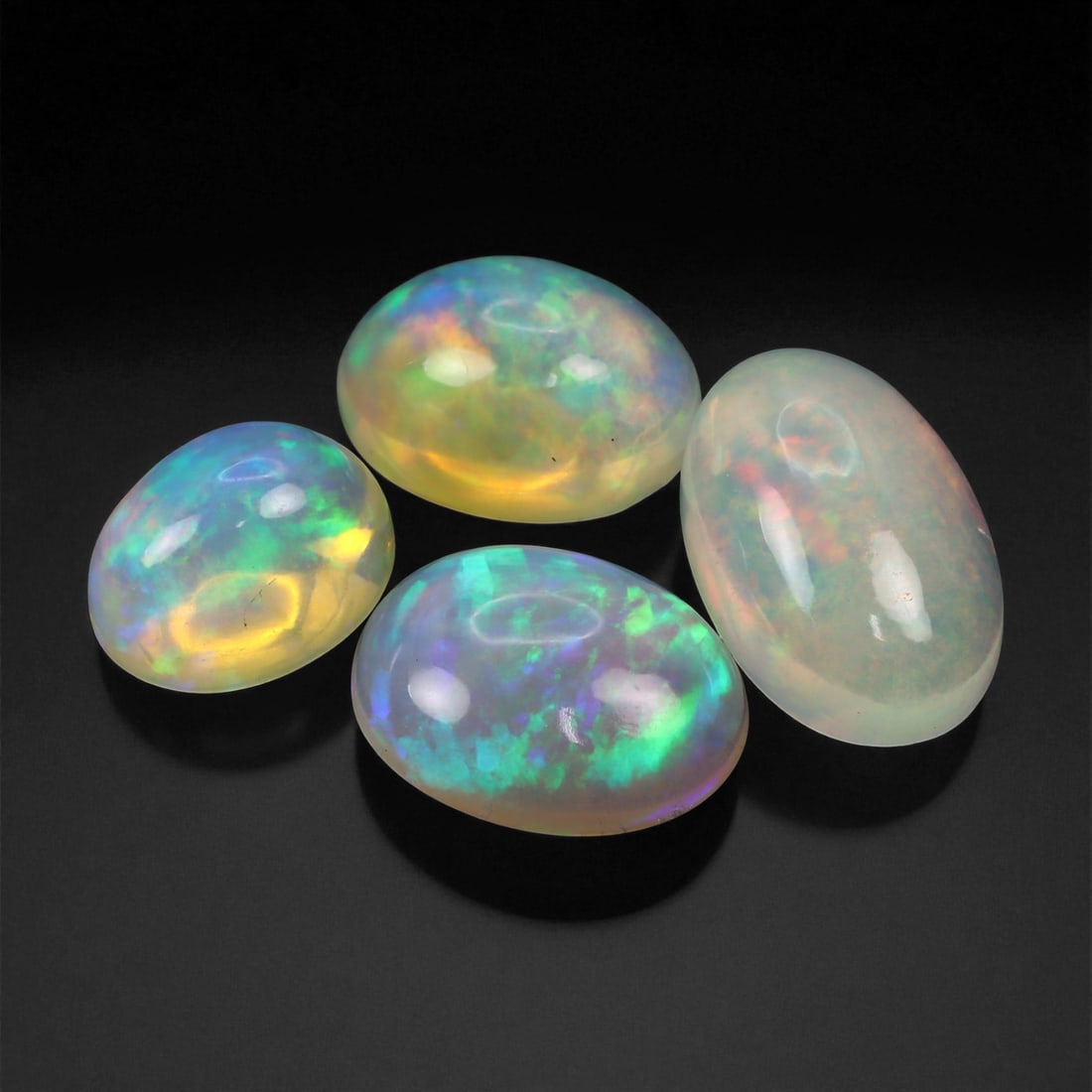 9.35 Carats Neon Play-of-Color Opal Selection - Natural Ethiopian Cabochons - 9 to 13 mm, 82XE: This luminous selection of opals radiates a dynamic spectrum of neon hues, with flashes of electric green, vivid orange, and spectral blue dancing across each dome. Their translucent base allows the i