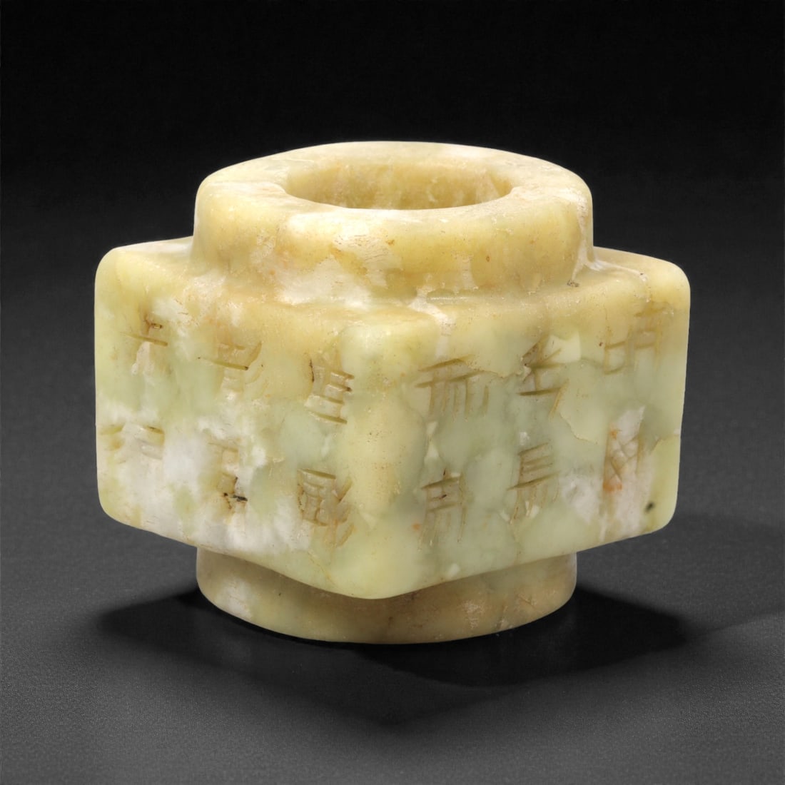 A Chinese Hetian Jade Cylindrical Ornament with Incised Characters, 20th Century, 93FH: Carved from mottled pale green and creamy-yellow Hetian jade, the object is formed as a stepped cylindrical vessel-like ornament with a thick-walled circular aperture and projecting shoulder. The exte