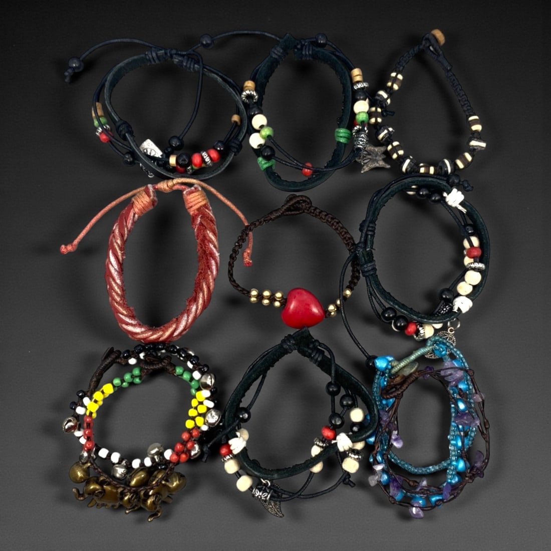 A Group of Eleven Leather and Beaded Bracelets, Late 20th-Early 21st Century, 32ZG: The group comprises eleven bracelets constructed primarily from leather cords combined with assorted beads and metal fittings. The designs vary and include braided, wrapped, and layered leather elemen