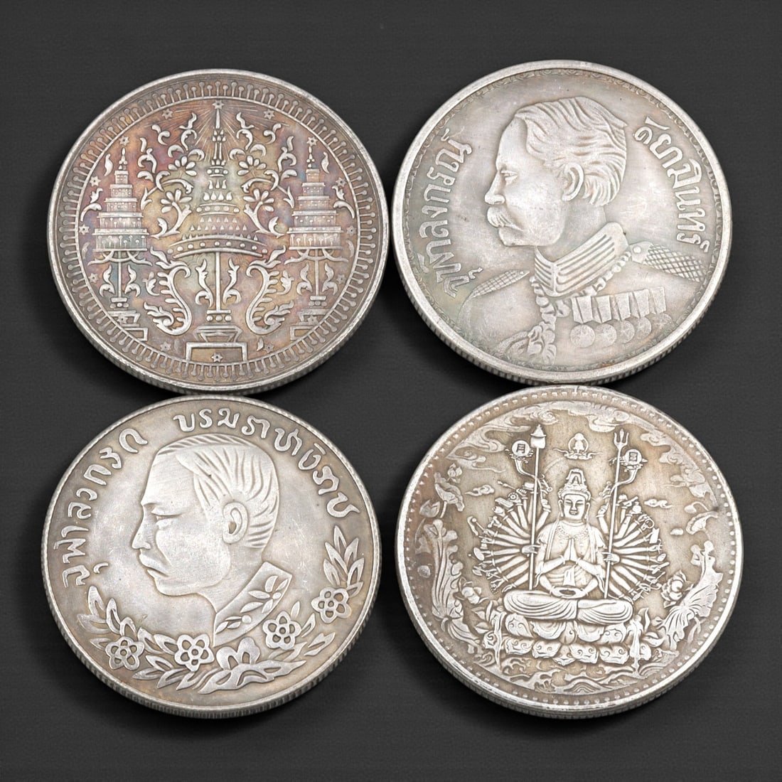 A Group of Four Chinese and Thai Commemorative Coins, 20th Century, 45FJ: The group comprises four circular commemorative coins, each measuring approximately 38 mm in diameter, struck in base metal alloy and produced for commemorative or collector purposes rather than circu