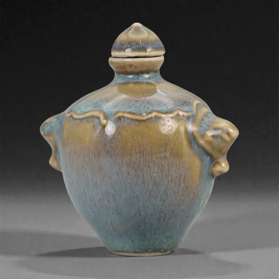 A Chinese Glazed Ceramic Snuff Bottle, 20th Century, 79FG: Thrown from a ceramic body and covered with a variegated blue and buff glaze, the snuff bottle is formed with a rounded ovoid body tapering to a narrow foot and rising to sloping shoulders beneath a s