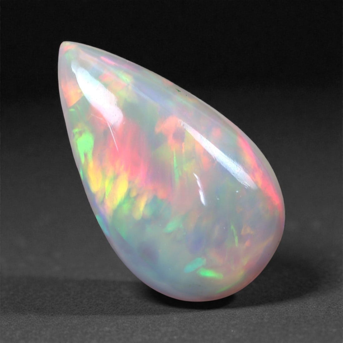 3.27 Carats Radiant Flame Welo Opal - Natural Ethiopian Gemstone 17x10x4.1mm, 1XH: An explosion of sunset hues bursts from this electrifying Welo opal, with brilliant flashes of hot pink, ember orange, lime green, and violet blazing beneath a translucent body. The fire is intense an