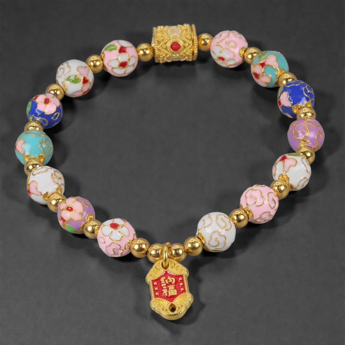 A Chinese Cloisonne Enamel Bracelet, 20th-21st Century, 91YB: Constructed as a circular bracelet composed of spherical cloisonne enamel beads alternating with small gilt metal spacers. The beads are decorated with opaque enamel grounds in white, pink, turquoise