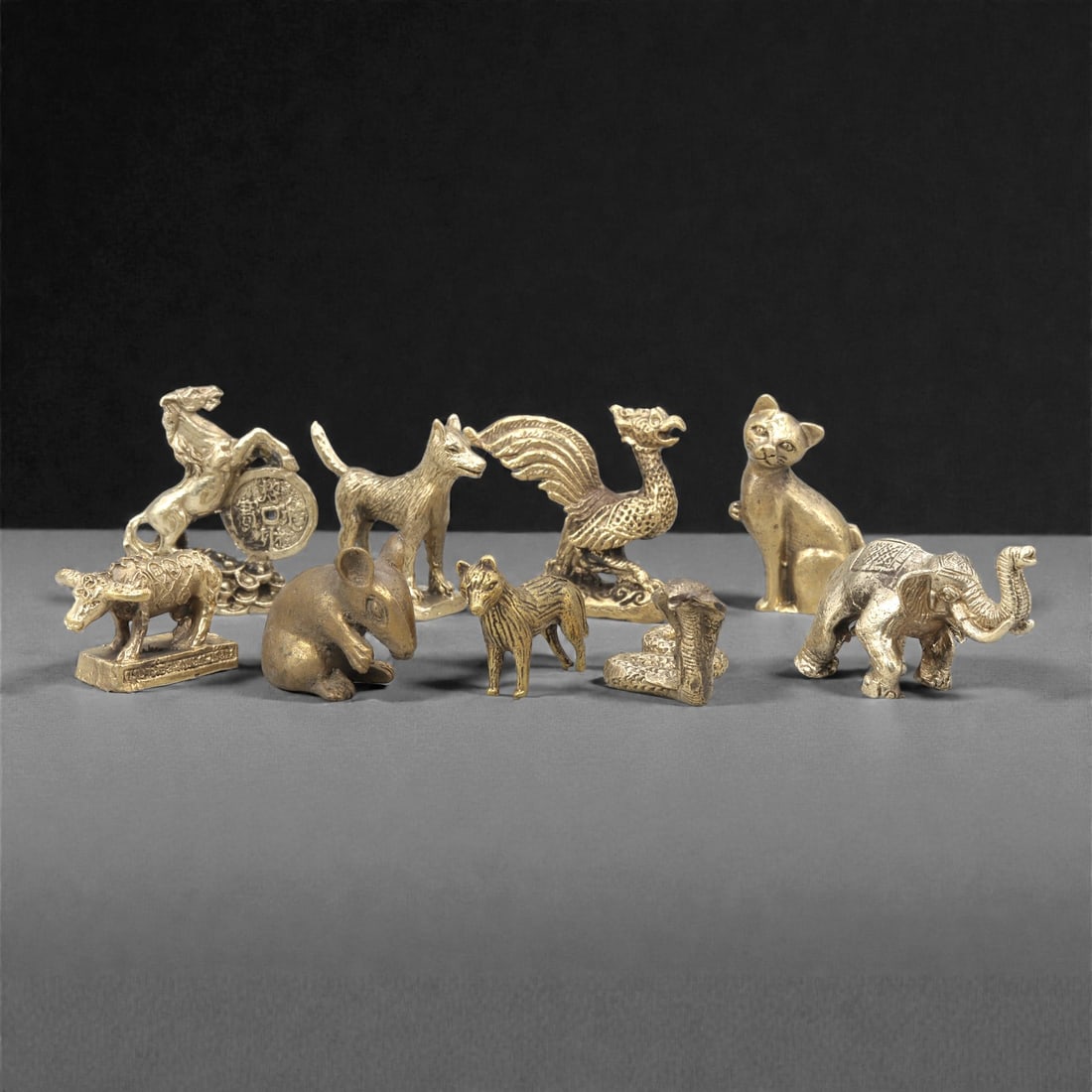 A Group of Thai Copper Alloy Animal Figures, 20th Century, 8ZG: Cast in copper alloy with gilt-toned surfaces and areas of darker patination, the group comprises a selection of small-scale animal figures, including both real and stylized forms. The assemblage incl