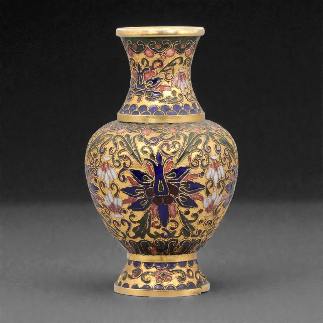 A Chinese Cloisonne Enamel Vase, 20th Century, 90YC: Constructed in copper and decorated with polychrome cloisonne enamel, the vase is formed with an ovoid body rising from a spreading foot and tapering to a waisted neck with a slightly flared rim. The