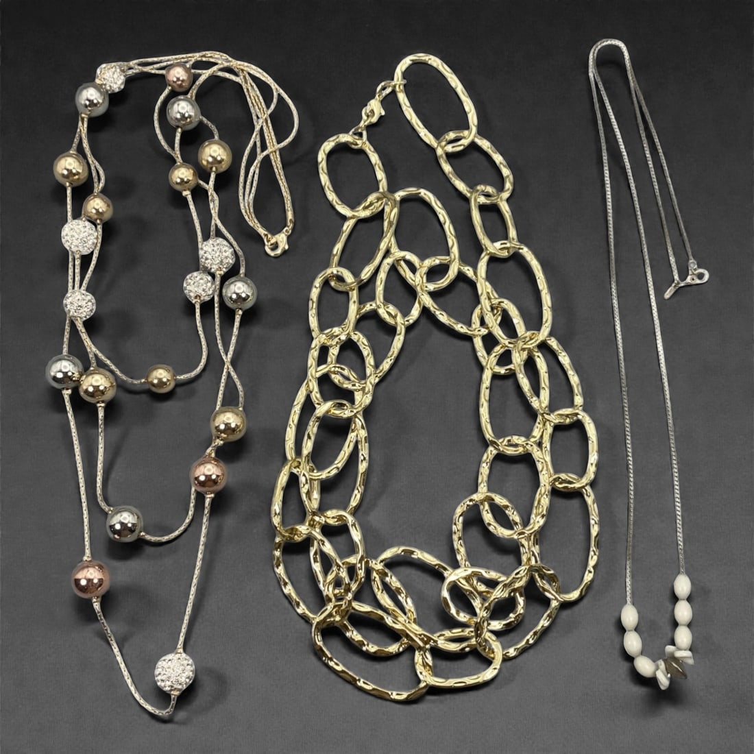 An Estate Lot of Three Necklaces, Late 20th-Early 21st Century, 43ZF: Comprising three necklaces of differing designs and construction. The first necklace is formed of white-colored metal strands with alternating spherical elements in silver-, gold-, and copper-toned fi