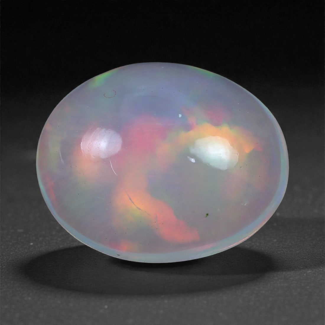 1.98 Carats Play-of-Color Welo Opal - Natural Ethiopian Gem 11x8mm, 27XC: This captivating Welo opal gleams with a luminous cascade of multi neon color that ripple across the stone's surface with every movement. The play-of-color is vivid and well-distributed, presenting a