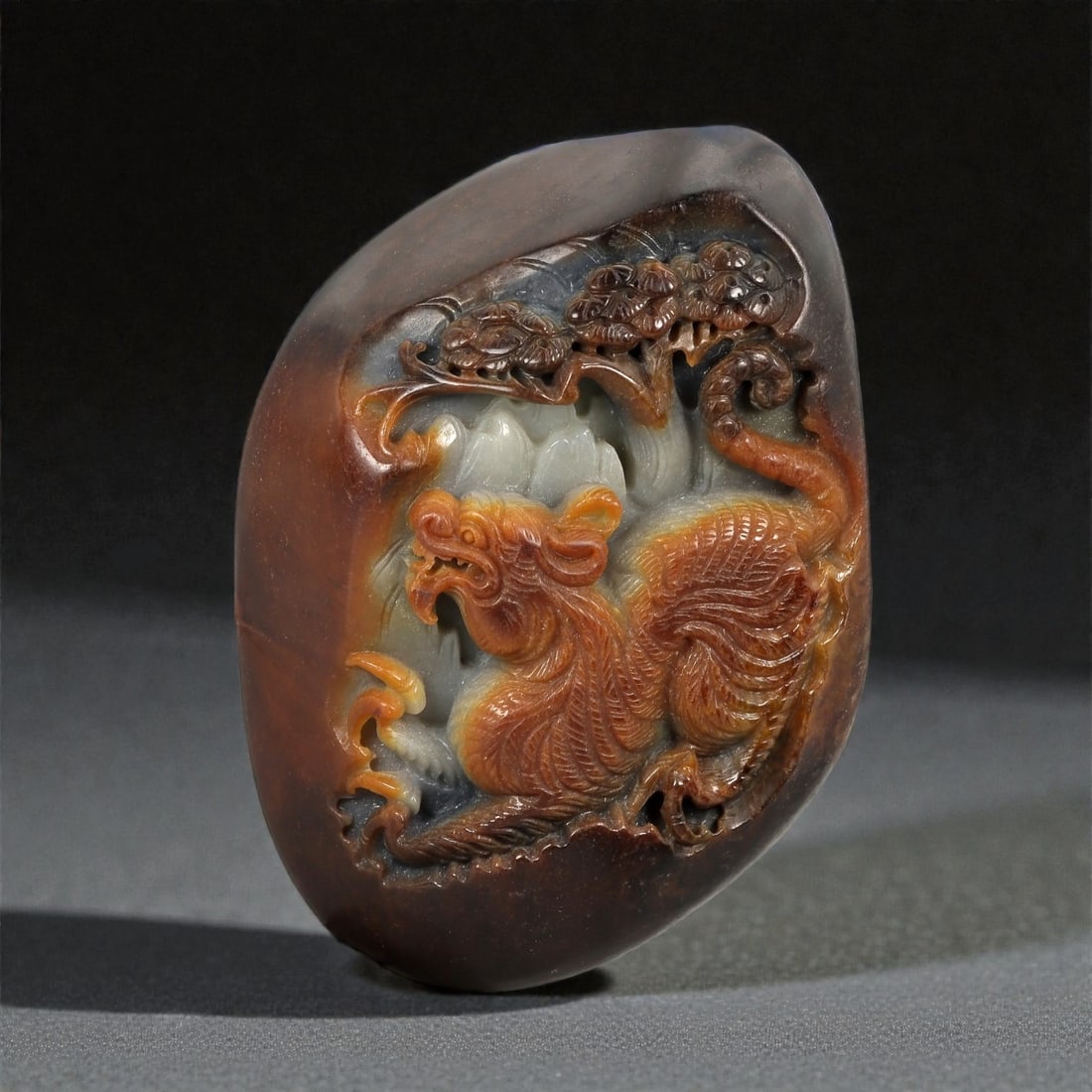 A Chinese Hetian Jade Mythical Beast Display Carving, 20th Century, 42FC: Carved from a richly colored piece of Hetian jade, this freestanding display carving depicts a mythical beast rendered in high relief against a softly contoured ground. The stone displays a striking r